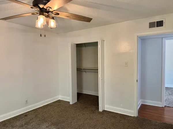 a bathroom with a toilet sink vanity granite and shower