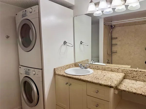a bathroom with a granite countertop sink a toilet and shower