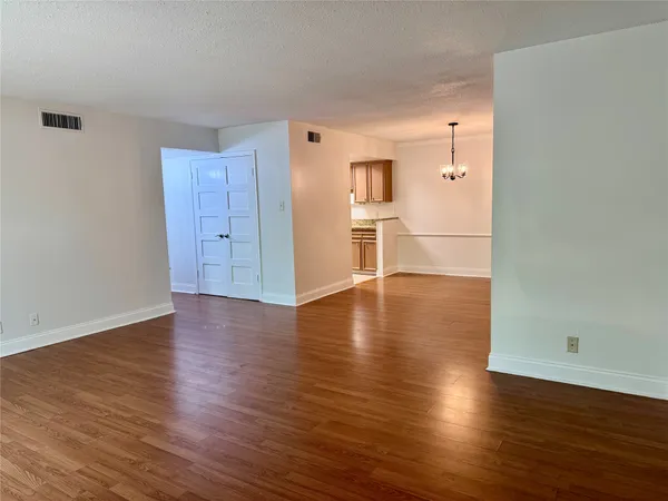 an empty room with wooden floor and closet