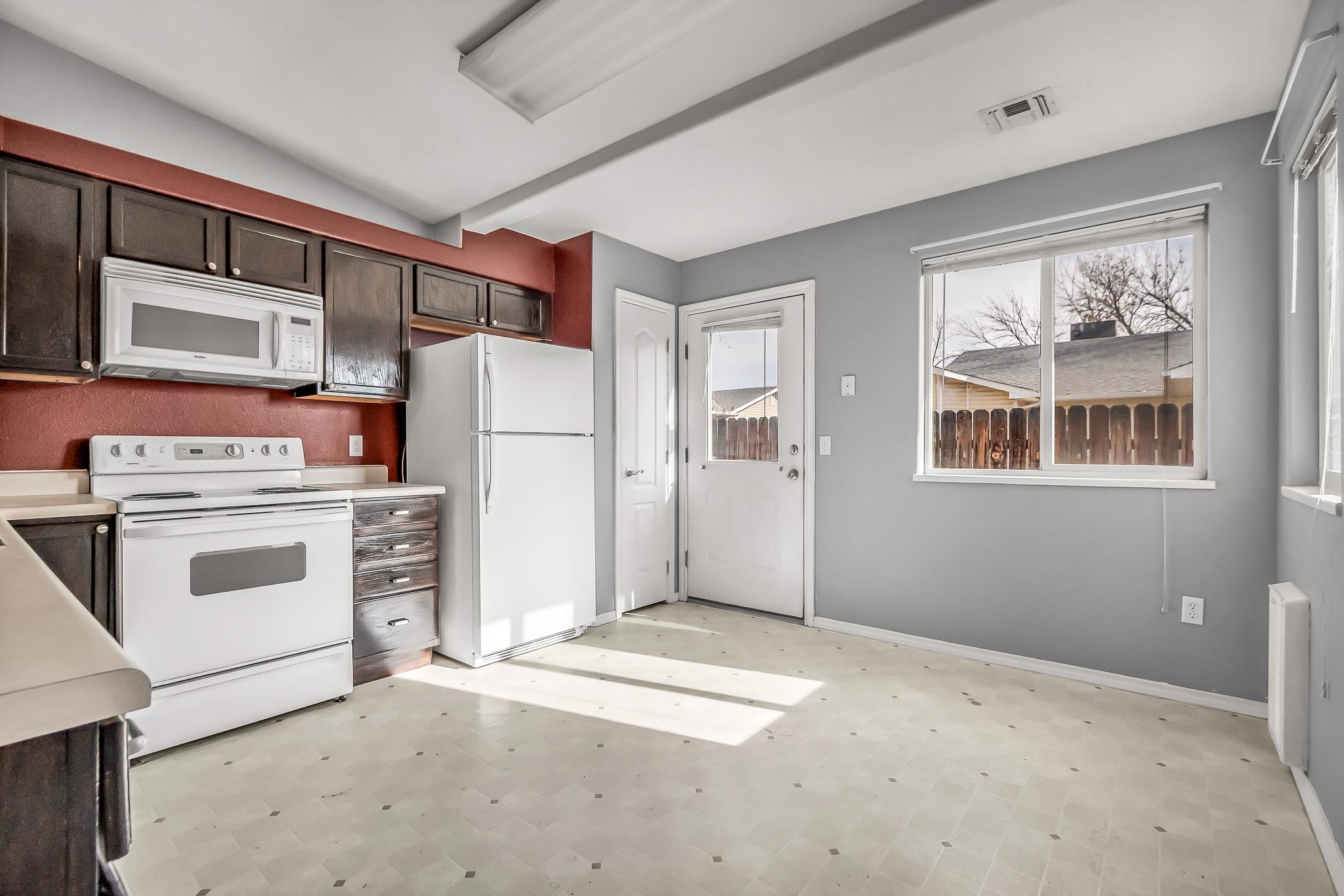 476 Ridge Lane Grand Junction, CO 81504 - Photo 5 of 22 a view of a kitchen with refrigerator and white cabinets