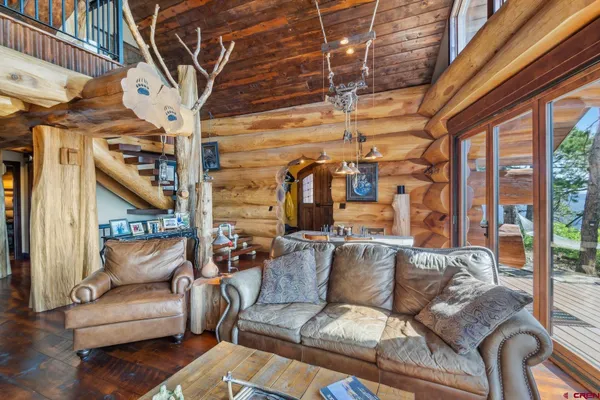 a view of a dining room with furniture one side kitchen view and wooden floor