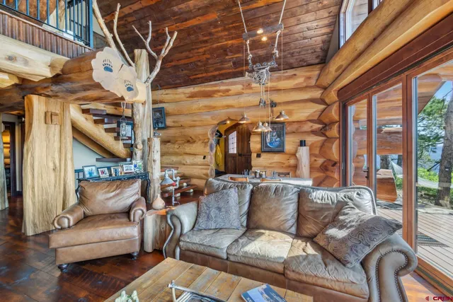 a view of a dining room with furniture one side kitchen view and wooden floor