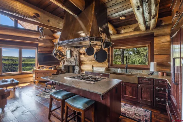 a kitchen with kitchen island granite countertop a sink a stove and a wooden cabinets