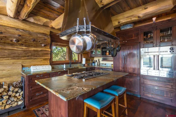 a bedroom with a bed a table and a dresser next to a window