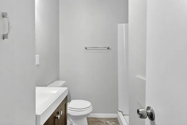 a white toilet sitting next to a shower