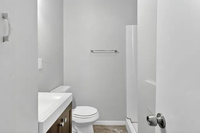 a white toilet sitting next to a shower
