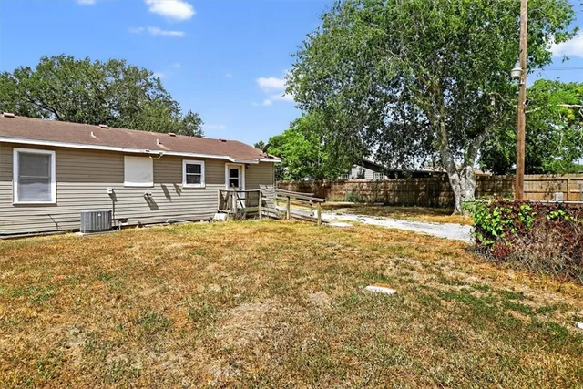 a front view of house with yard and trees in the background