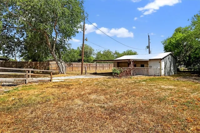 a view of a house with backyard and a tree