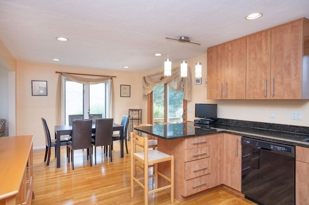 25 Sandy Ridge Road Stoughton, MA 02072 - Photo 15 of 42 a open kitchen with granite countertop a dining table chairs and white cabinets
