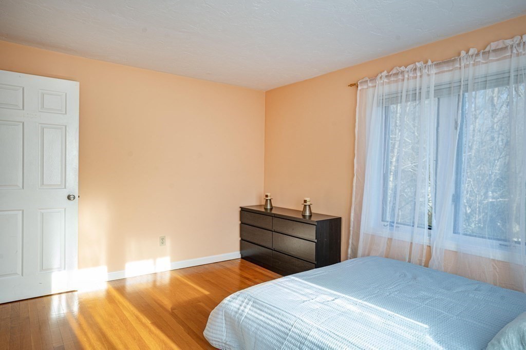 25 Sandy Ridge Road Stoughton, MA 02072 - Photo 23 of 42 a bedroom with a bed and wooden floor