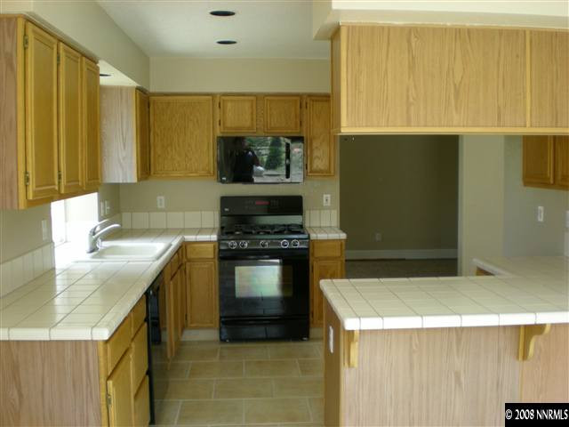 1440 Moon Lane Reno, NV 89521 - Photo 3 of 9 a kitchen with stainless steel appliances granite countertop a sink a stove top oven a counter space and cabinets