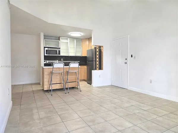 a view of kitchen with furniture and refrigerator