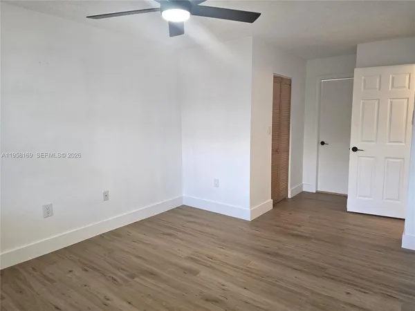 a view of an empty room with wooden floor