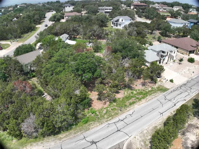 an aerial view of residential houses with outdoor space and trees