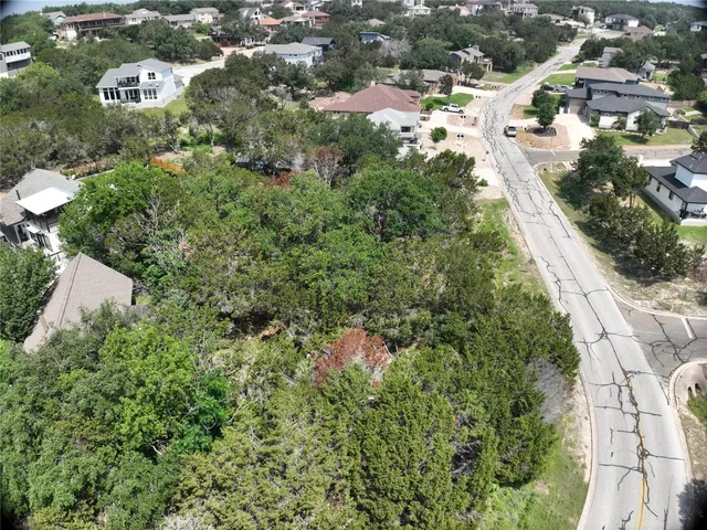 an aerial view of residential houses with outdoor space and trees