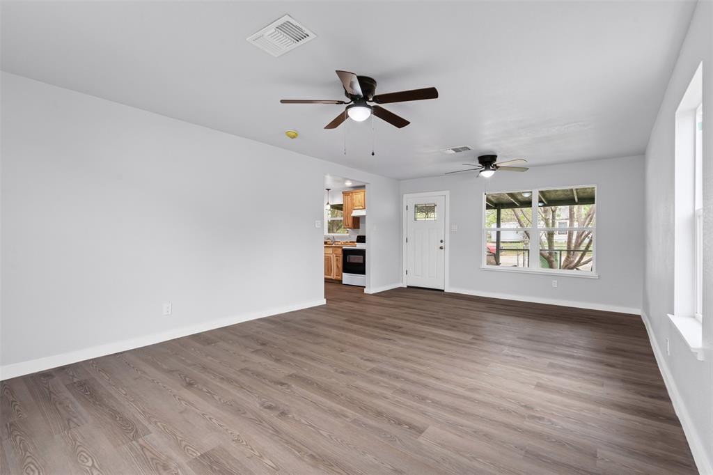1205 Southwest 12th Street Mineral Wells, TX 76067 - Photo 11 of 23 an empty room with wooden floor ceiling fan and windows