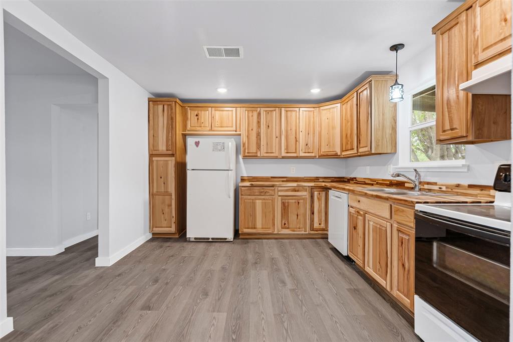 1205 Southwest 12th Street Mineral Wells, TX 76067 - Photo 12 of 23 a kitchen with a refrigerator sink and cabinets