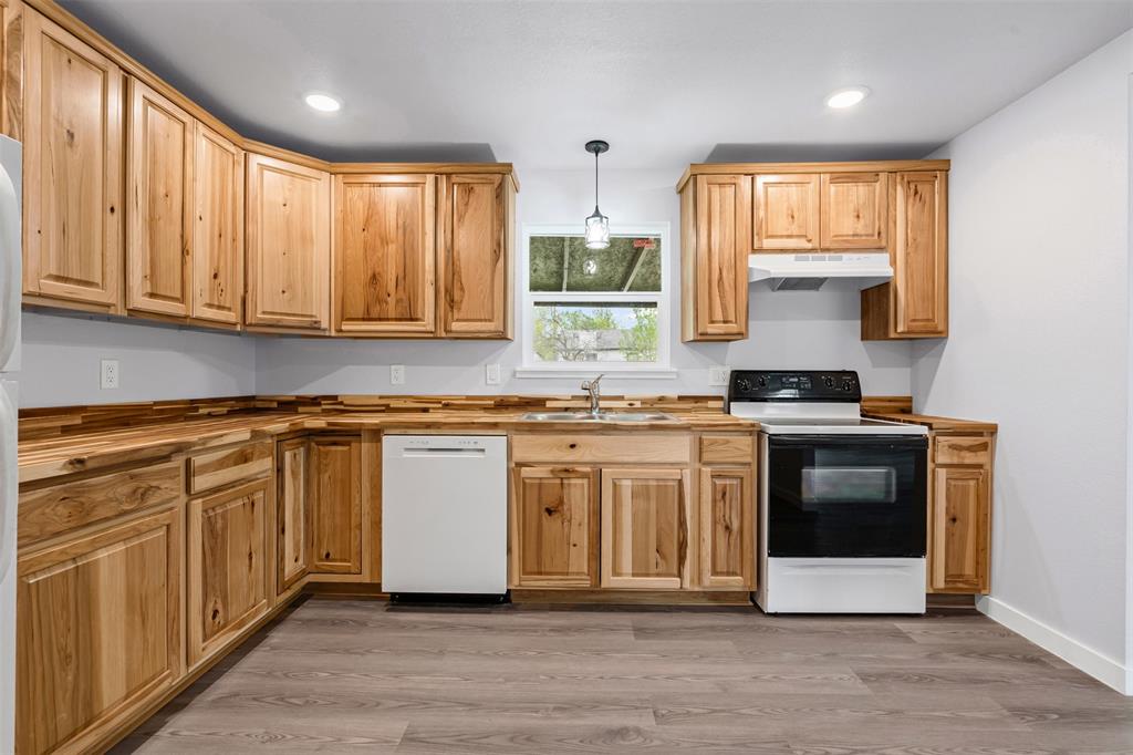 1205 Southwest 12th Street Mineral Wells, TX 76067 - Photo 14 of 23 a kitchen with stainless steel appliances granite countertop a stove a sink and a microwave