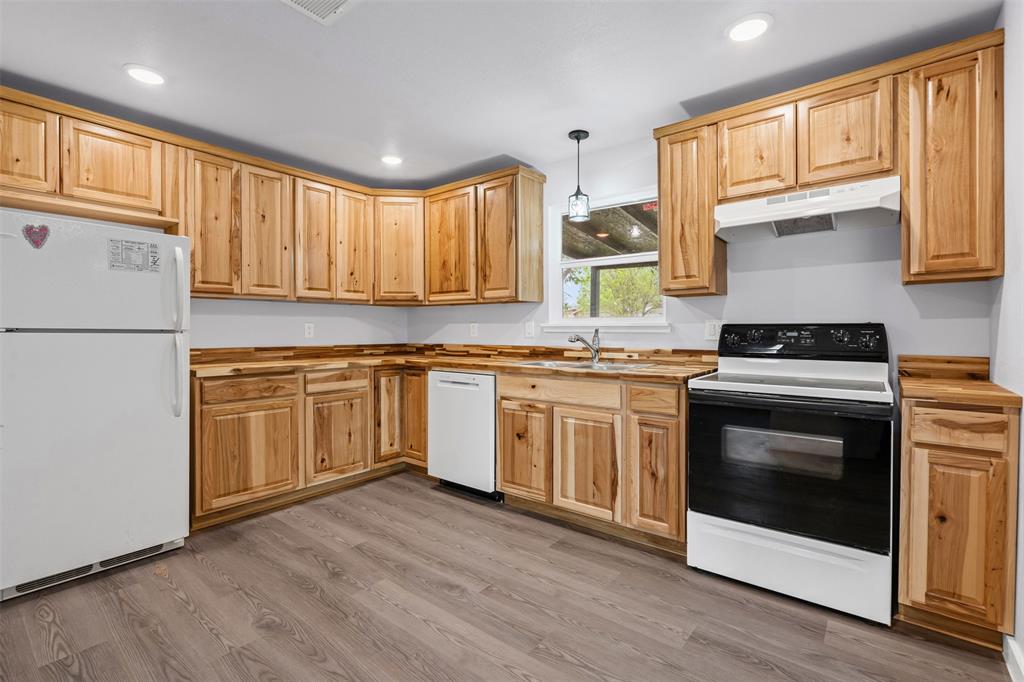 1205 Southwest 12th Street Mineral Wells, TX 76067 - Photo 15 of 23 a kitchen with granite countertop white cabinets and white appliances