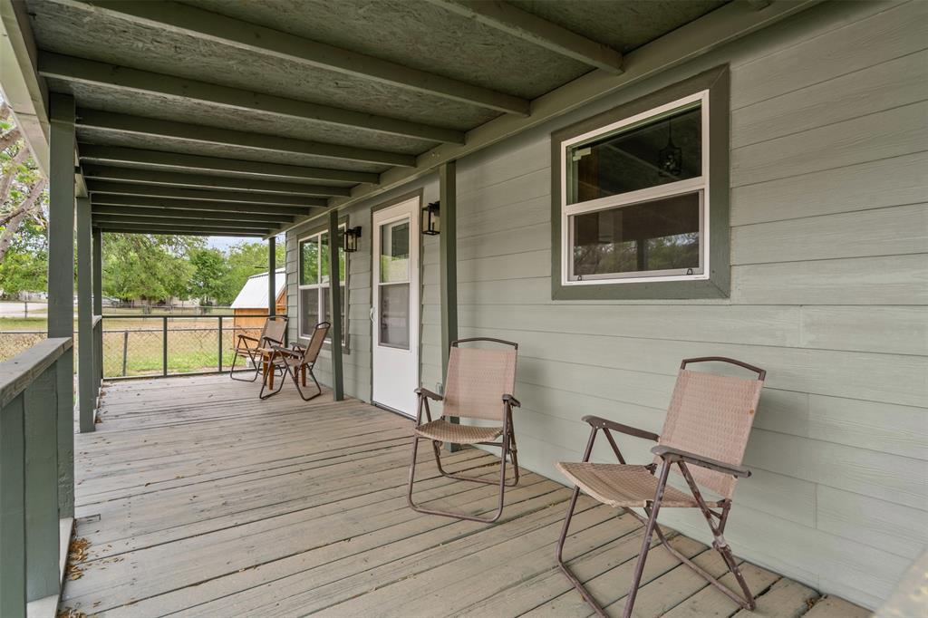 1205 Southwest 12th Street Mineral Wells, TX 76067 - Photo 6 of 23 a balcony with table and chairs and potted plants with wooden floor