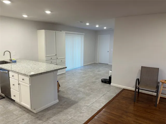 a kitchen with a sink cabinets and wooden floor