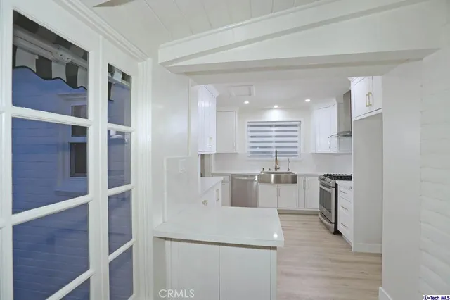 a kitchen with a sink stove top oven and cabinets
