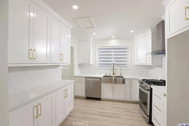 a kitchen with stainless steel appliances granite countertop a sink stove and cabinets