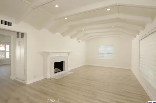 a view of empty room with wooden floor and fireplace
