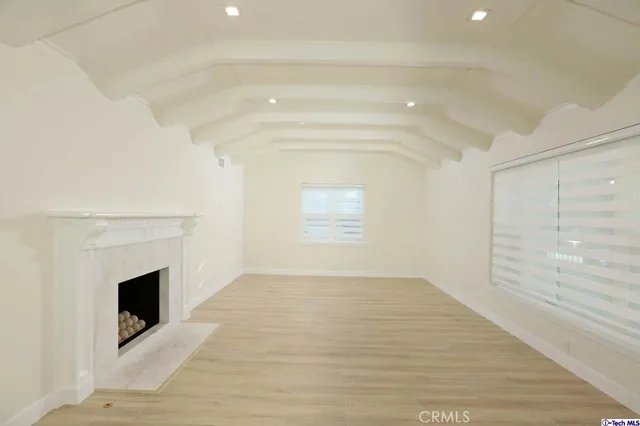 a view of empty room with a fireplace and windows