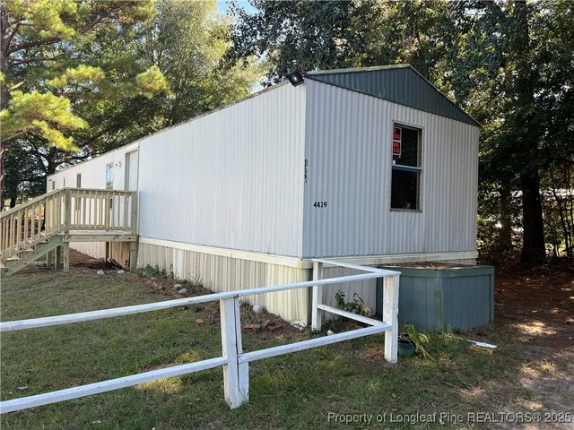 a view of backyard with deck and outdoor seating