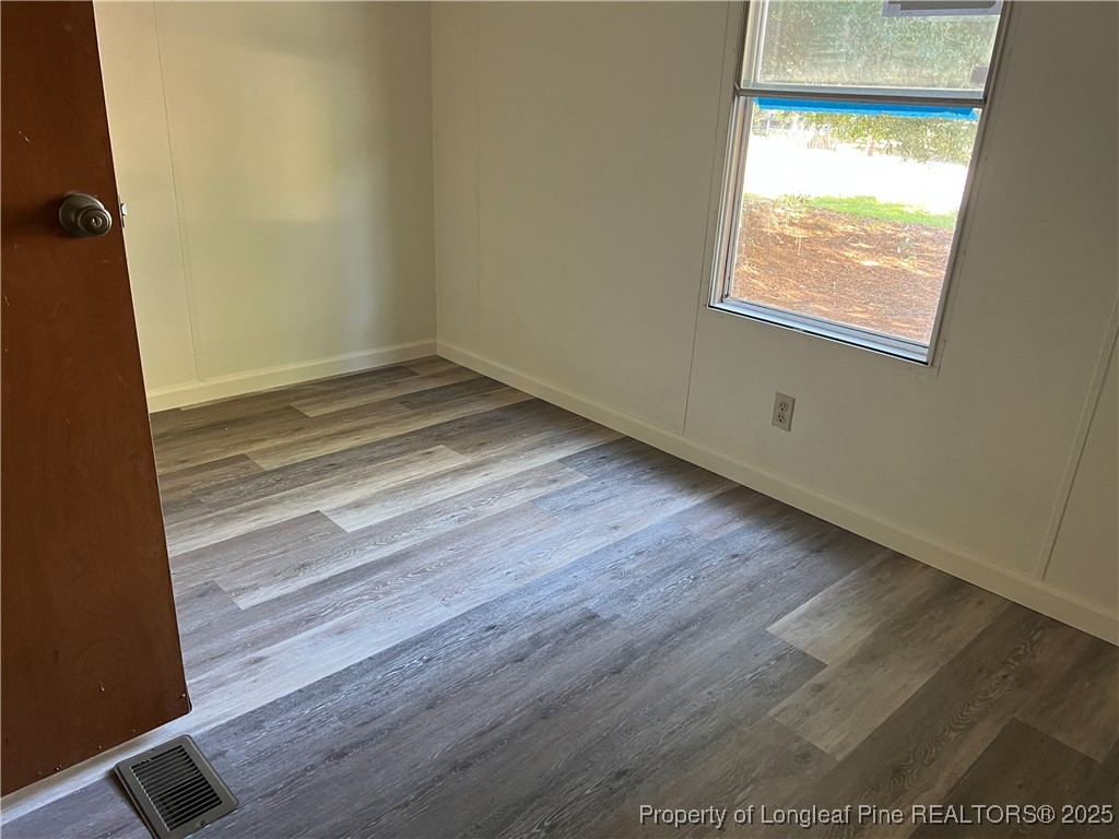 4439 Betsy Ross Drive Hope Mills, NC 28348 - Photo 7 of 9 a view of an empty room with wooden floor and a window