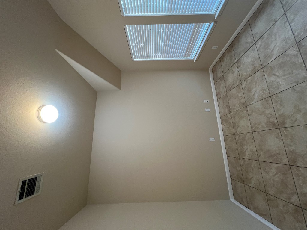 129 Holmstrom Street Hutto, TX 78634 - Photo 11 of 26 Flex Room-Spare room featuring visible vents, baseboards, a textured ceiling, vaulted ceiling, and light tile patterned flooring