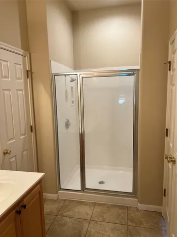 a bathroom with a shower sink and mirror