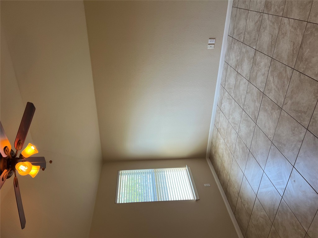 129 Holmstrom Street Hutto, TX 78634 - Photo 17 of 26 Tiled empty room featuring ceiling fan and baseboards