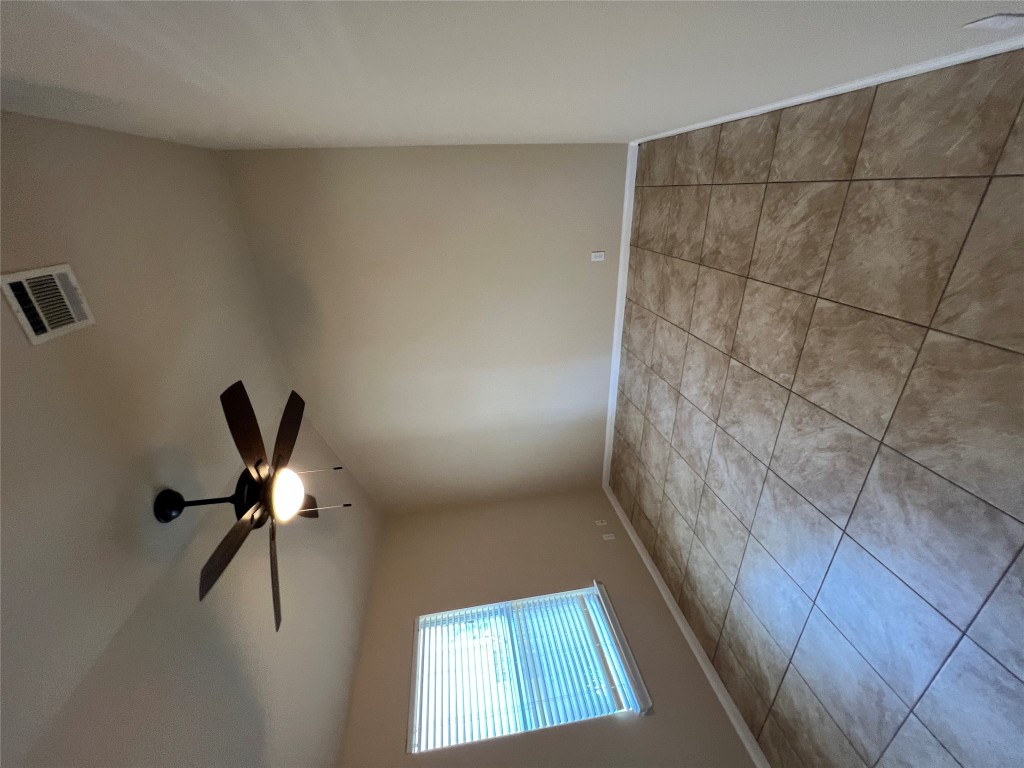 129 Holmstrom Street Hutto, TX 78634 - Photo 19 of 26 Tiled spare room featuring lofted ceiling, visible vents, baseboards, and ceiling fan