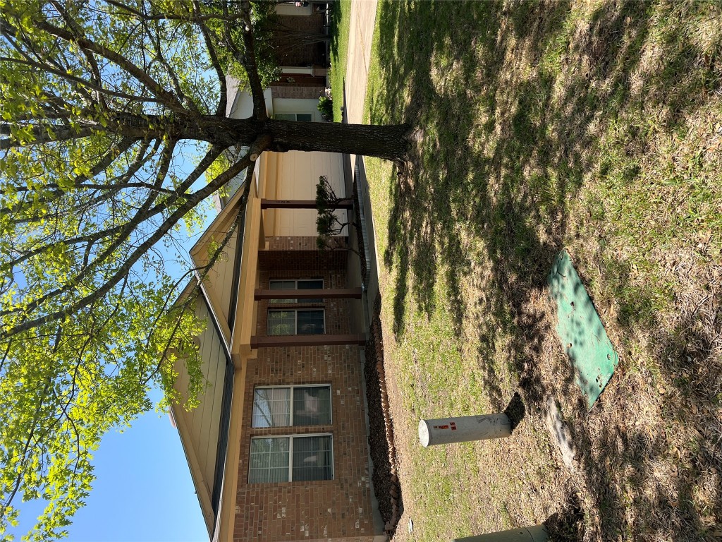 129 Holmstrom Street Hutto, TX 78634 - Photo 2 of 26 View of front of home featuring concrete driveway, brick siding, a front lawn, and an attached garage