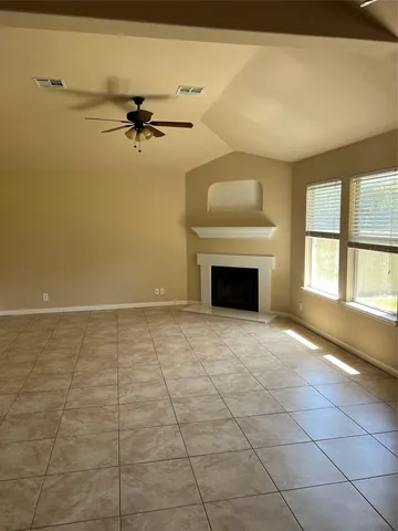 an empty room with windows and fireplace