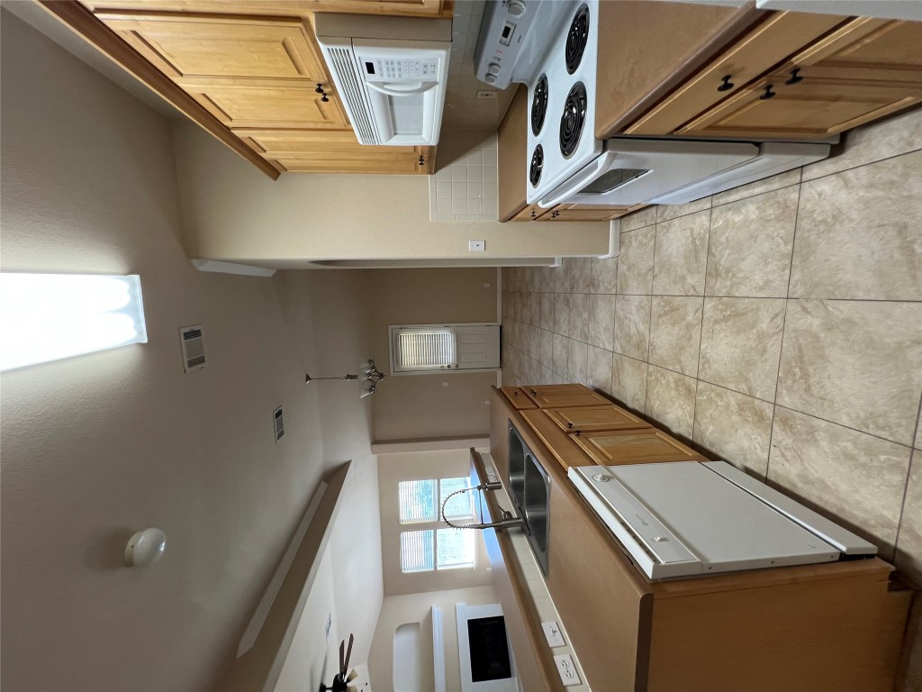 129 Holmstrom Street Hutto, TX 78634 - Photo 6 of 26 Kitchen featuring stove, dishwasher, a sink, and visible vents