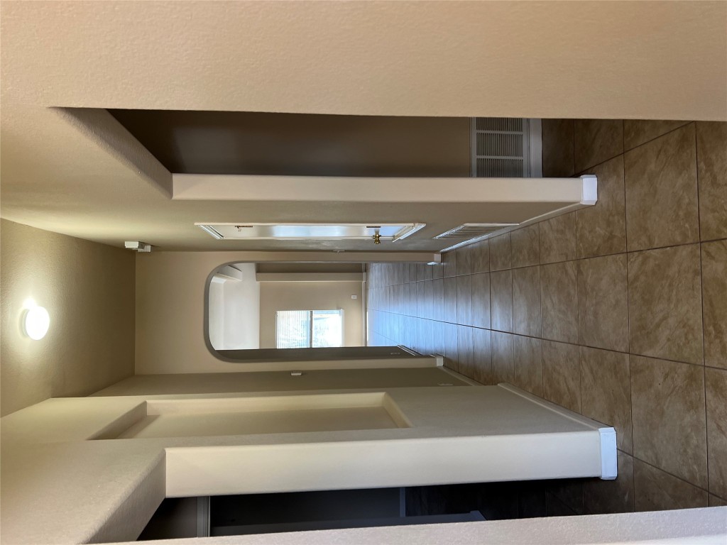 129 Holmstrom Street Hutto, TX 78634 - Photo 7 of 26 Corridor with tile patterned floors, arched walkways, visible vents, and baseboards