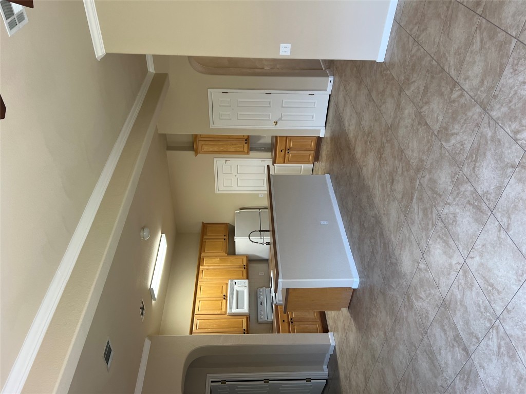 129 Holmstrom Street Hutto, TX 78634 - Photo 8 of 26 Kitchen featuring visible vents, arched walkways, ornamental molding, refrigerator, and range