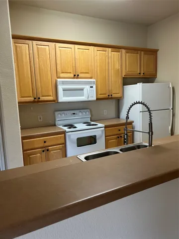 a view of a kitchen with a sink and cabinets