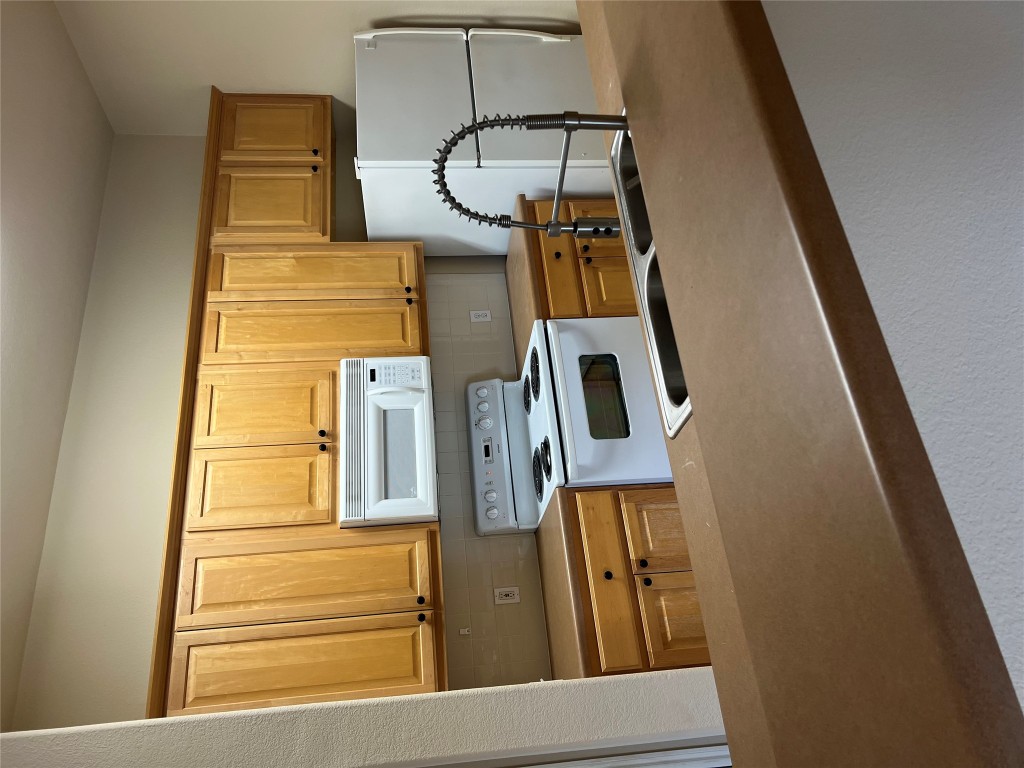 129 Holmstrom Street Hutto, TX 78634 - Photo 9 of 26 Kitchen featuring a sink, tasteful backsplash, fridge, and range with electric cooktop
