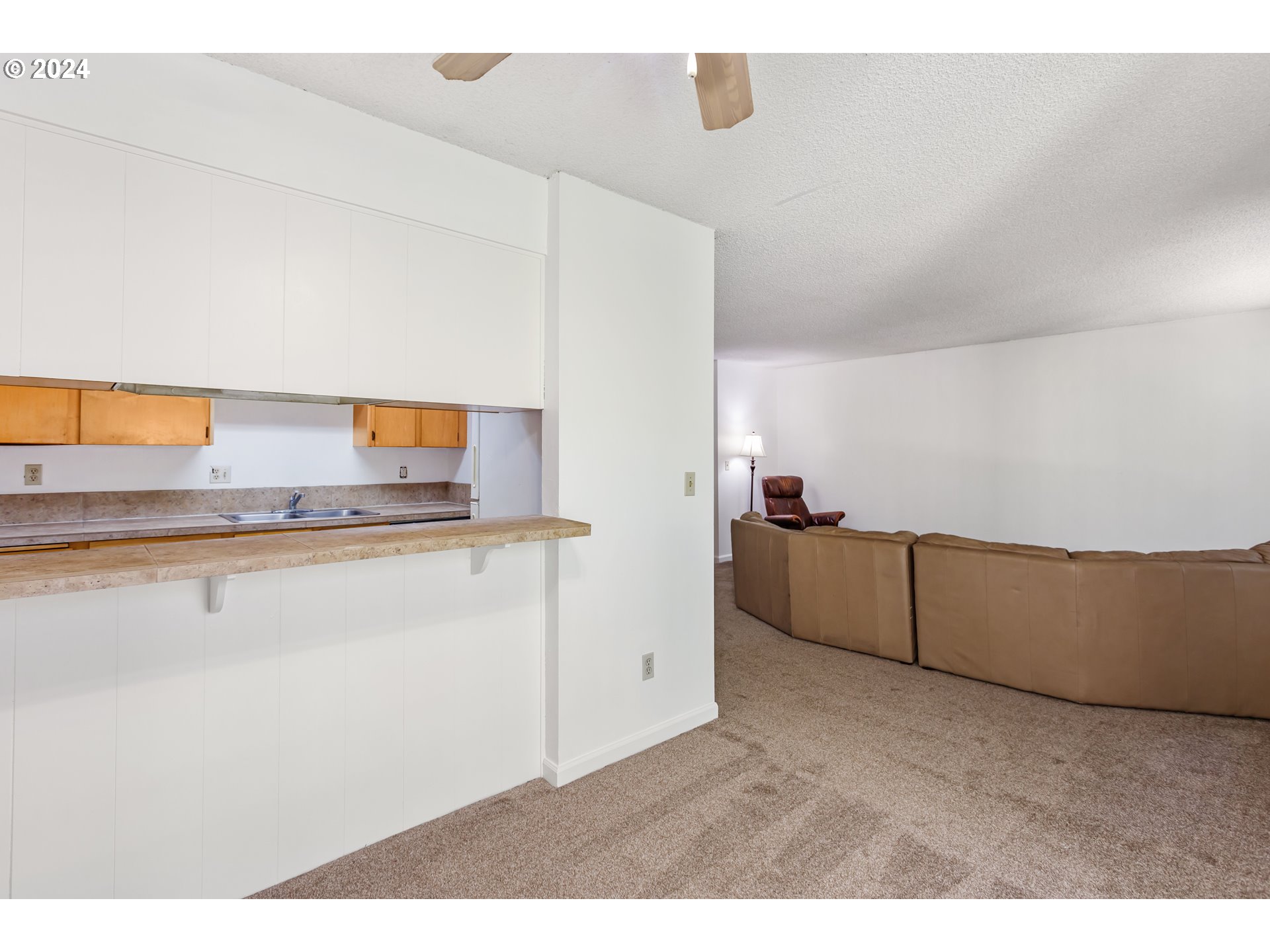 11377 Southwest Springwood Drive, Unit 34 Portland, OR 97223 - Photo 12 of 28 a kitchen with cabinets and wooden floor