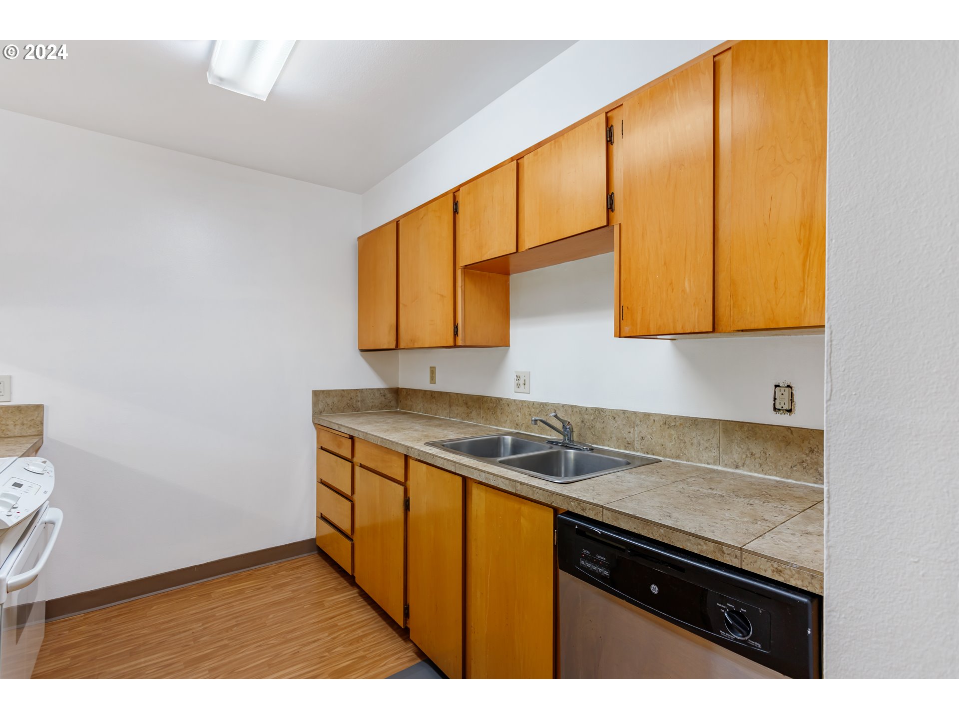 11377 Southwest Springwood Drive, Unit 34 Portland, OR 97223 - Photo 14 of 28 a kitchen with stainless steel appliances granite countertop a sink and cabinets