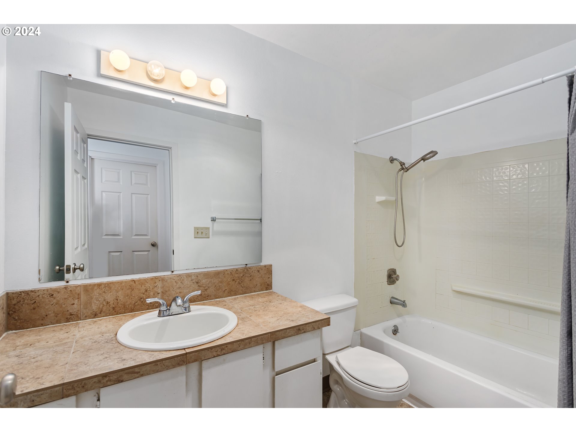 11377 Southwest Springwood Drive, Unit 34 Portland, OR 97223 - Photo 20 of 28 a bathroom with a granite countertop sink a toilet a mirror and shower