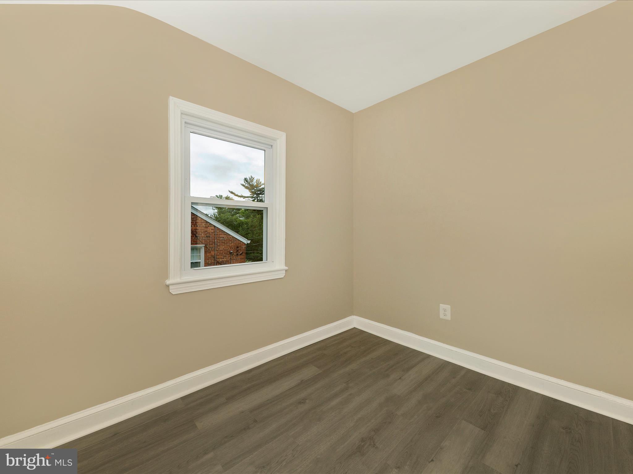 8709 Bradford Road Silver Spring, MD 20901 - Photo 28 of 51 a view of an empty room with wooden floor and a window