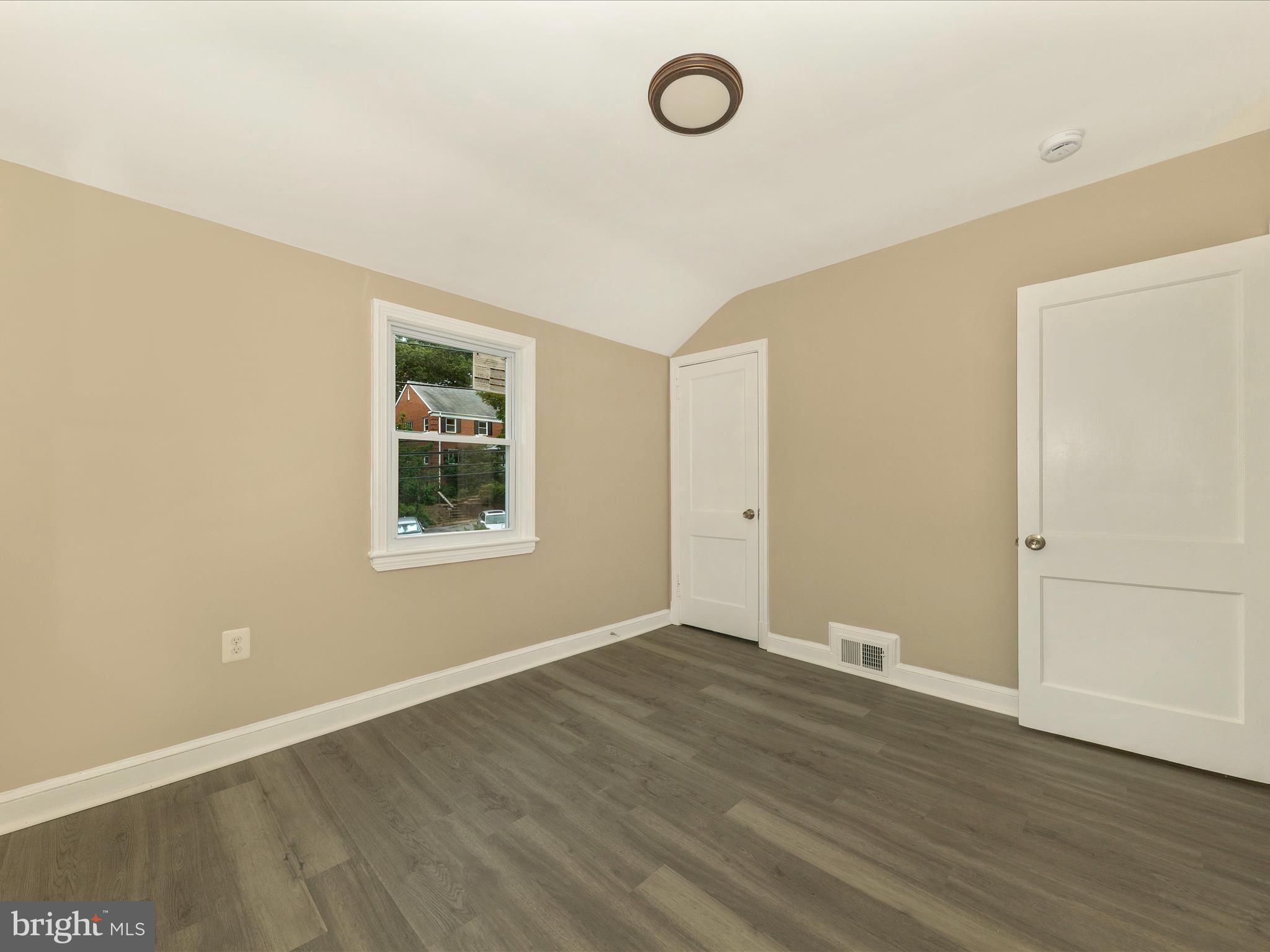 8709 Bradford Road Silver Spring, MD 20901 - Photo 30 of 51 an empty room with wooden floor and window