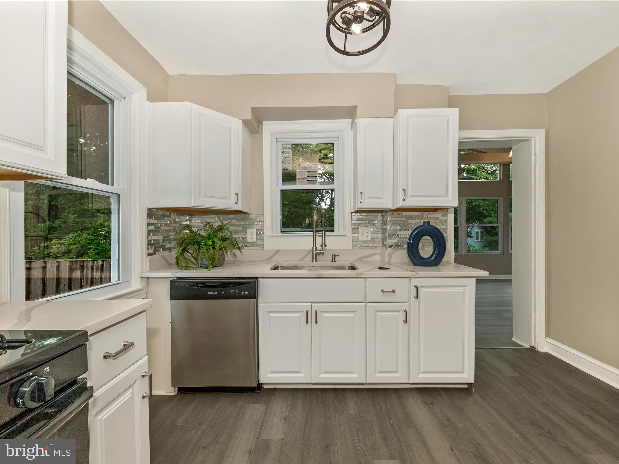 8709 Bradford Road Silver Spring, MD 20901 - Photo 8 of 51 a kitchen with stainless steel appliances white cabinets a stove a sink and a window