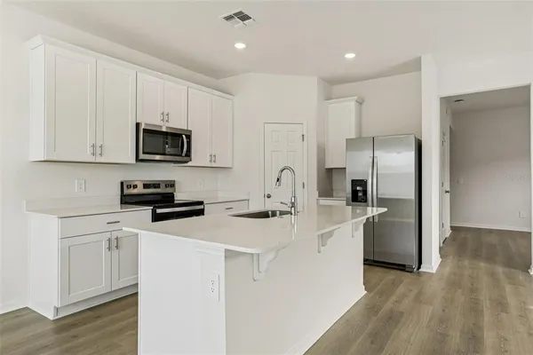 a kitchen with stainless steel appliances granite countertop a stove a sink and a refrigerator