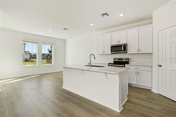 a kitchen with stainless steel appliances granite countertop a stove a sink and a refrigerator